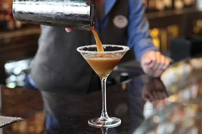 Bartender pouring a martini.