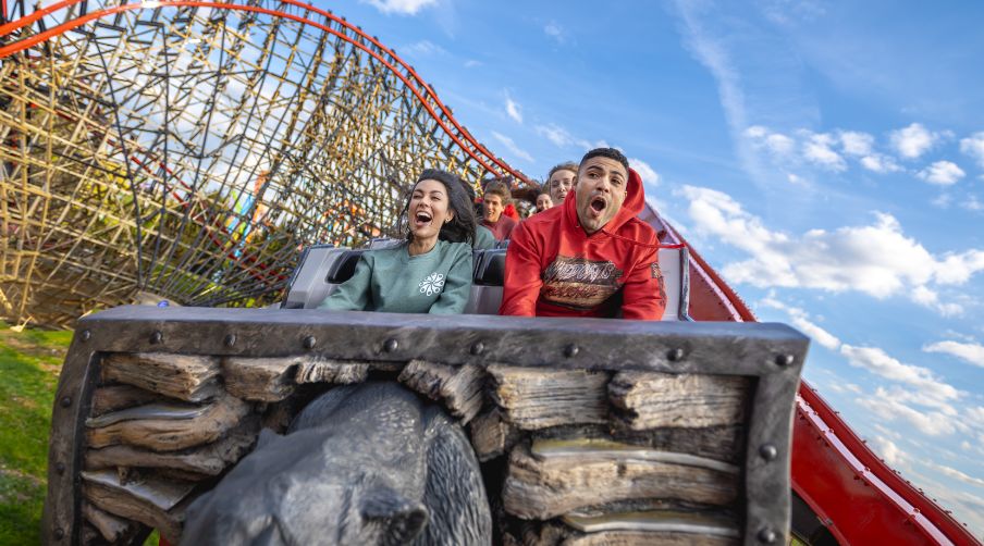 Two guests in Wildcats Revenge gear riding front row on coaster.